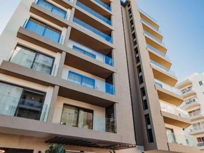 Moderner mehrstöckiger Hotelbau mit großen Fenstern und Balkonen unter klarem Himmel.