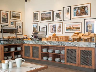 Buffetbereich mit Geschirr und Frühstückszubehör in einem Hotelrestaurant.