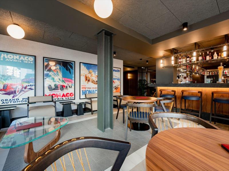 Modern eingerichtete Bar mit verschiedenen Sitzgelegenheiten und beleuchtetem Tresen