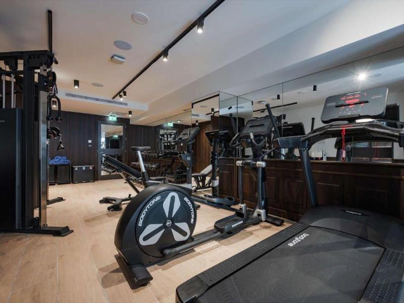 Fitnessraum mit modernen Trainingsgeräten und Holzboden in einem Hotel