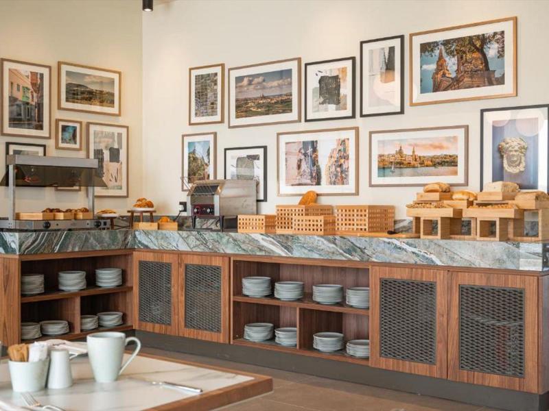 Buffetbereich mit Geschirr und Frühstückszubehör in einem Hotelrestaurant.