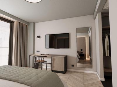 Chambre d'hôtel moderne avec lit, téléviseur, bureau et grande fenêtre avec rideaux.