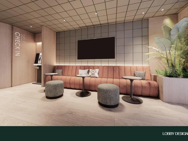 Área de descanso moderna de hotel con sofá gris, mesas, taburetes y una planta grande.