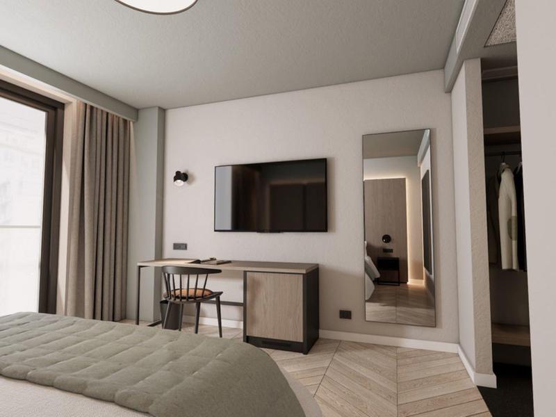 Habitación de hotel moderna con cama, escritorio, televisor y grandes ventanas con cortinas.