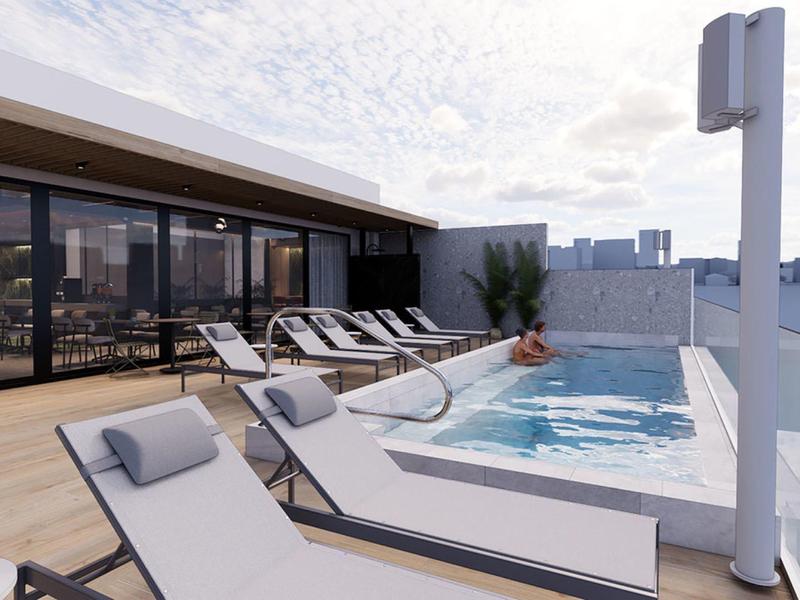 Terraza en la azotea moderna con piscina, tumbonas y vista a la ciudad a la luz del día.