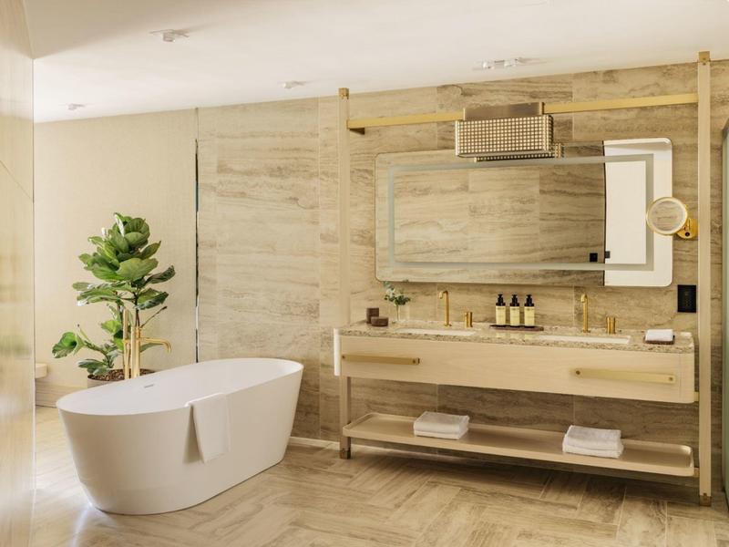 Moderní koupelna s volně stojící vanou a velkým dřevěným umyvadlem se zrcadlem.