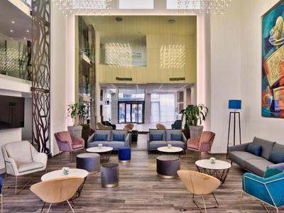 Nowoczesna strefa lounge hotelu z różnymi miejscami do siedzenia i kolorowymi akcentami.