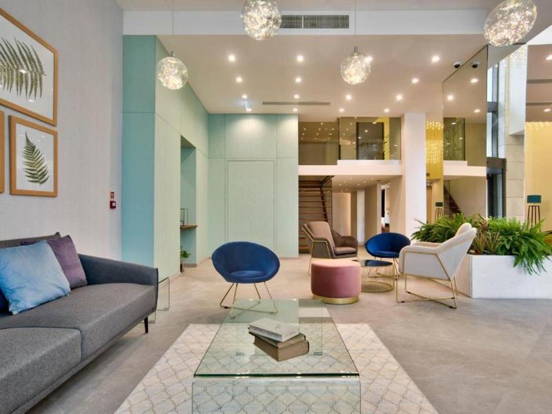 Moderne hotel lobby met elegante zitplaatsen, glazen tafels en zachte verlichting.