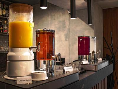 Getränkespender mit Orangensaft, Tee und Saft in einem eleganten Hotelbuffet.