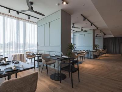 Restaurant moderne avec sol en bois, grandes fenêtres et mobilier gris.