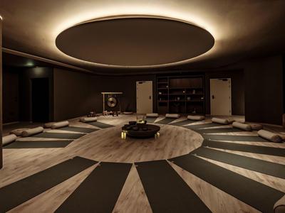 Runder Meditationsraum mit Kissen und dunkler Einrichtung in einem Hotel.