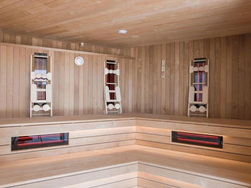 Panche e pareti in legno chiaro in una sauna finlandese moderna.