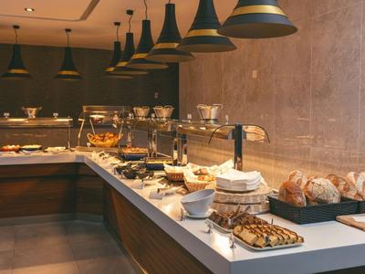 Bufetová část v moderním hotelu s různými pečivami a teplými pokrmy.