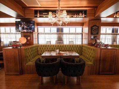 Pohodlný posezení v hotelové restauraci s dřevěným obložením a lustr.