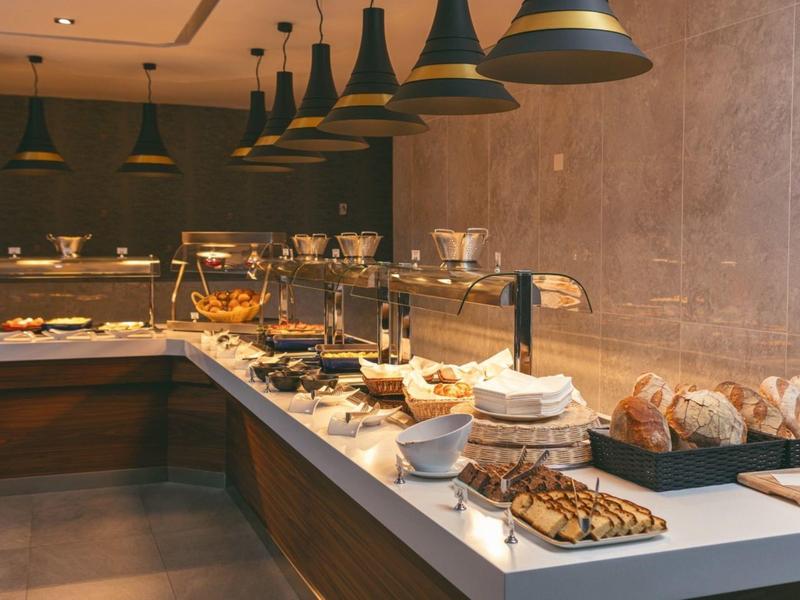 Bufet s různými pečivem a teplými jídly v moderní hotelové restauraci