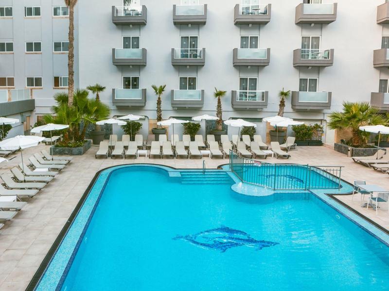 Velký bazén s lehátky na nádvoří hotelu.