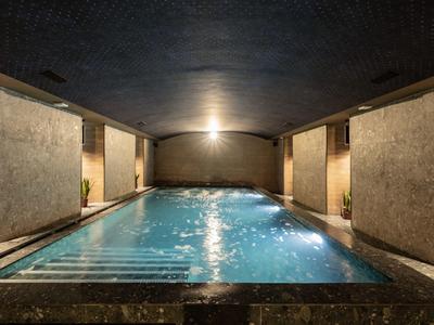 Piscine intérieure chauffée avec éclairage tamisé et design moderne dans un hôtel