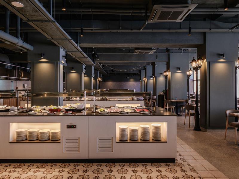 Buffet moderne dans un restaurant d'hôtel élégant et bien éclairé avec une décoration sombre.