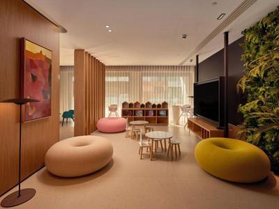 Modern hotel lounge area with round seating and plenty of natural light.