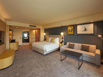 Chambre d'hôtel moderne avec un grand lit et un canapé confortable.