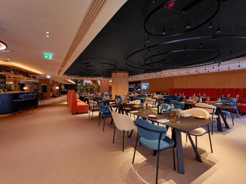 Restaurant moderne avec des sièges confortables et un intérieur élégant aux couleurs chaudes.