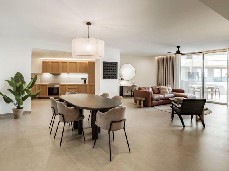 Nowoczesny salon i jadalnia z brązowymi meblami i dużymi oknami.