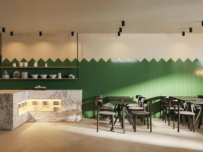 Area ristorazione moderna con parete piastrellata verde, banconi in marmo bianco e sedie nere ai tavoli in legno