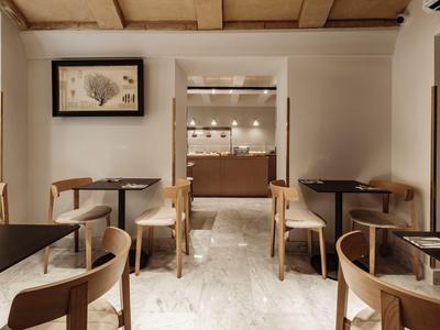 Accogliente area pranzo dell'hotel con mobili in legno e pavimento in marmo.