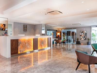 Heller und moderner Hotellobby-Empfangsbereich mit Beleuchtung und Sitzgelegenheiten.