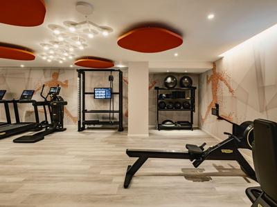 Moderner Fitnessraum mit Laufbändern, Rudergerät und Krafttraining im Hotel.