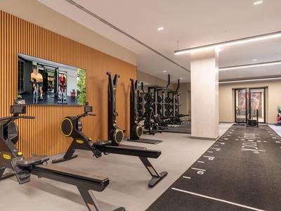 Moderne fitnessruimte met gewichten en trainingsapparatuur in een hotel.