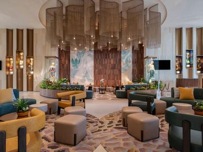 Modern ingerichte hotellobby met comfortabele zitplaatsen en decoratieve elementen.