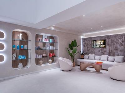 Moderne wellnessruimte met comfortabele fauteuils en schappen vol verzorgingsproducten.