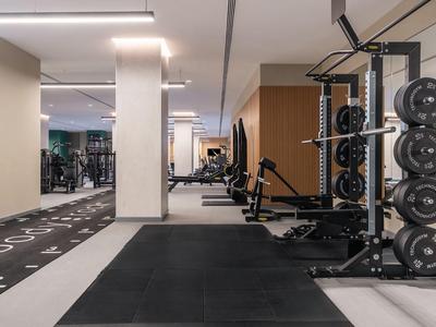 Moderne sportschool met halters, fitnessapparaten en spiegels in een hotel.