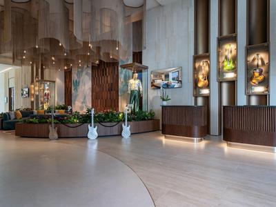 Moderne hotellobby met gezellige zithoeken, houten vloeren en sfeerverlichting.