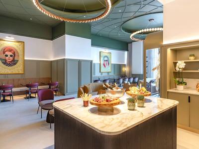 Elegante hotel lounge met moderne meubels en verlicht buffet.