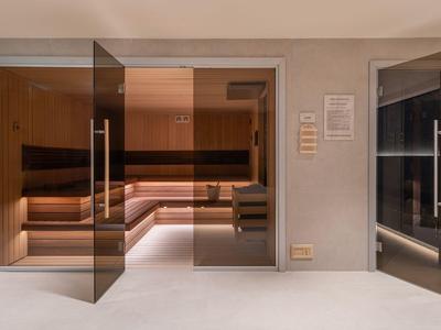 Moderne spa met een grote sauna, zachte verlichting en warme houttinten.