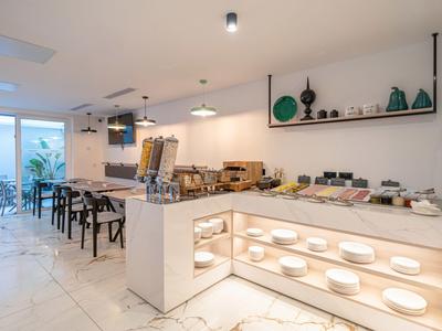 Modernes Hotelbuffet mit Sitzbereich, weißem Interieur und dekorativen Vasen.