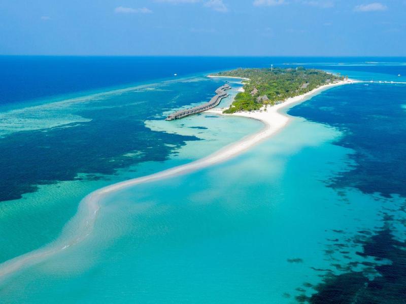 Luftaufnahme einer schmalen Insel mit weißem Sand und türkisfarbenem Wasser.