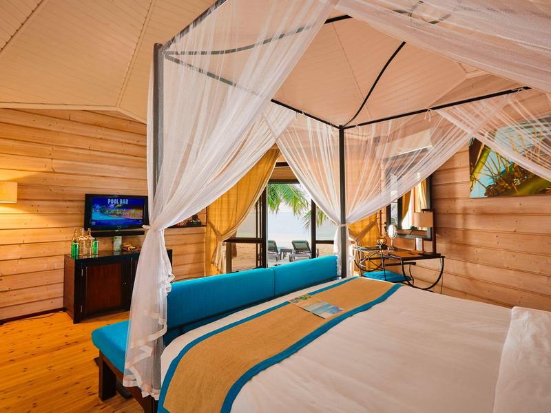 Gemütliches Zimmer mit Himmelbett, Holzwänden und Meerblick durch die Fenster