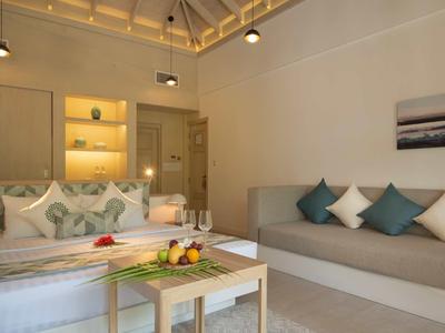 Modern eingerichtetes Wohnzimmer mit Sofa, Couchtisch, Dekokissen und gedeckten Farben.