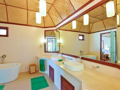 Helles Badezimmer mit freistehender Badewanne, großem Spiegel und Doppelwaschbecken.