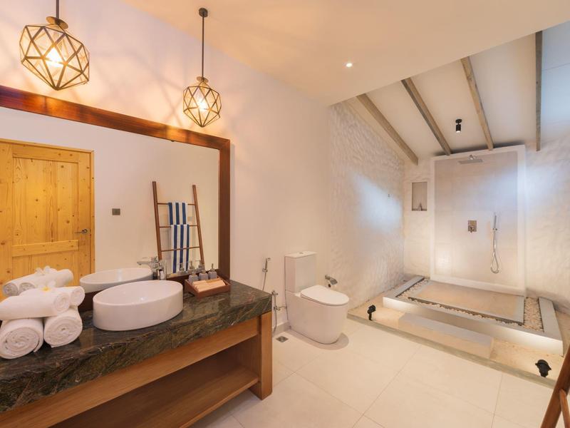 Modernes Badezimmer mit Holzdetails, großer Badewanne, runder Waschbecken und warmem Licht.