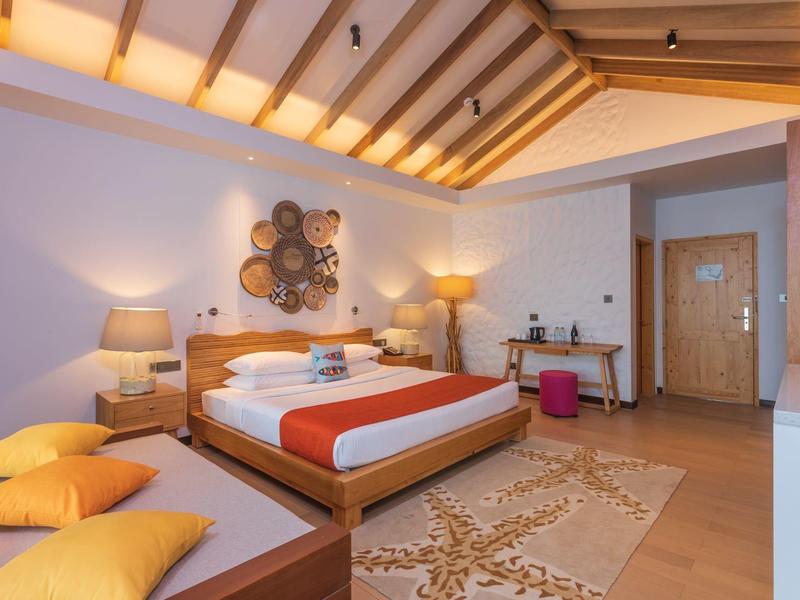 Modernes Schlafzimmer mit Doppelbett, Holzmöbeln, Teppich und indirekter Deckenbeleuchtung.