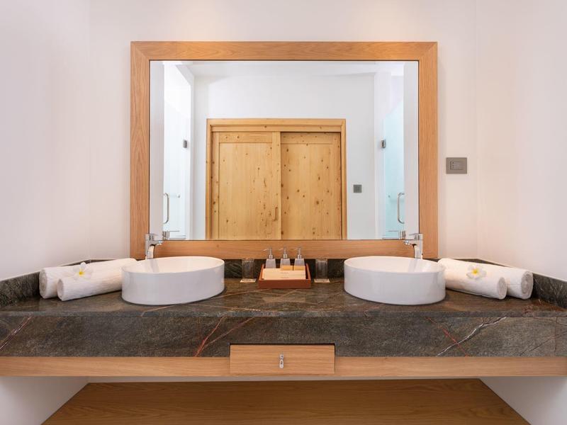 Modernes Badezimmer mit Doppelwaschbecken, großem Spiegel und schwarzen Marmorarbeitsplatten.