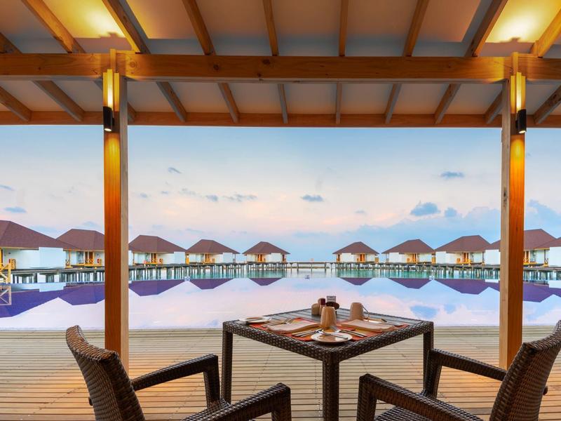 View of overwater bungalows from the covered restaurant with wooden ceiling.