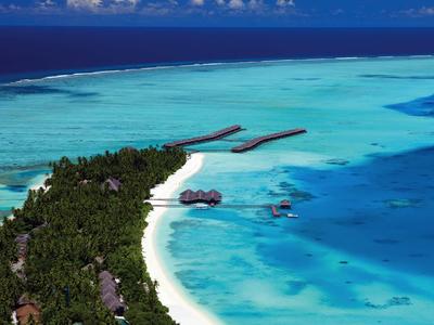 Luftaufnahme einer tropischen Insel mit weißem Sandstrand und türkisfarbenem Wasser.