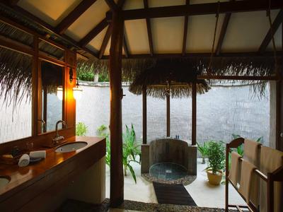 Pohodlná veranda s dřevěným nábytkem s výhledem do zahrady v tropickém hotelu.