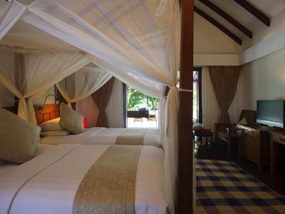 Pohodlný hotelový pokoj s nebesy, atmosférickým osvětlením a televizí v teplém prostředí.