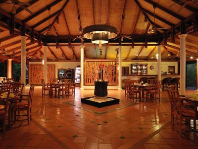 Area ristorante accogliente dell'hotel con mobili in legno e soffitto aperto di notte.